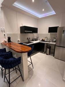 a kitchen with a wooden table and blue chairs at CYRUS Appart in Pointe-à-Pitre