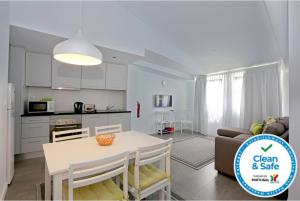 a kitchen and a living room with a table and a couch at APARTAMENTOS ALMEIDA GARRETT in Ponta Delgada +20 photos