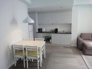 a kitchen and living room with a table and chairs at APARTAMENTOS ALMEIDA GARRETT in Ponta Delgada