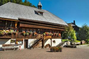 a large wooden building with flower boxes on it at Drei Tannen - Wohnung 09 - Apartmenthaus, Titisee, Feldberg in Titisee-Neustadt +17 photos