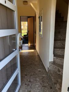 un couloir d'une maison avec une porte et des escaliers dans l'établissement To Hus, Reihenhaus 6, à Kellenhusen