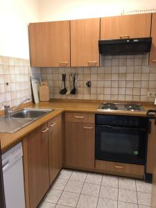 - une cuisine avec des placards en bois, une cuisinière et un évier dans l'établissement To Hus, Reihenhaus 6, à Kellenhusen