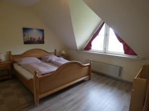 - une chambre mansardée avec un lit en bois dans l'établissement To Hus, Reihenhaus 6, à Kellenhusen