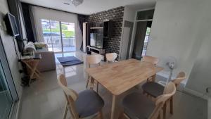 a dining room with a wooden table and chairs at A,B house Chiangmai in Chiang Mai