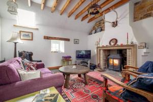 ein Wohnzimmer mit Couch und Kamin in der Unterkunft Park View Cottages - The Granary in Boarhills
