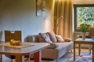 a living room with a couch and a table at Drei Tannen - Wohnung 05 - Apartmenthaus, Titisee, nahe Badeparadies in Titisee
