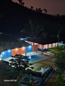 a building with a swimming pool at night at Chalé das hortênsias in Bonito