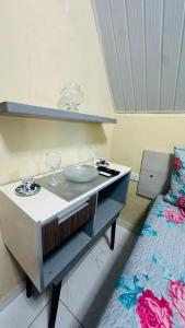 a dresser with glasses on it next to a bed at Chalé das hortênsias in Bonito