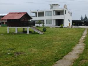 a large white house with a yard with a building at Hospedaje gardenias in Chignahuapan