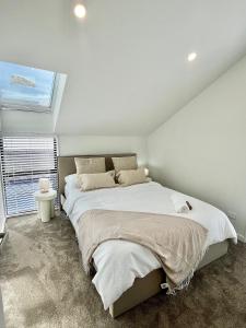 una camera da letto con un letto grande e una finestra di New build City Townhouse & Gated Car Park a Christchurch