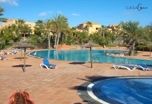 basen z leżakami i parasolami w ośrodku w obiekcie Rentalfue Tamarindo 1 casa Grace w Corralejo