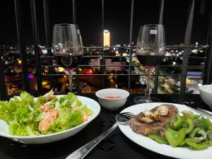 a table with two plates of food and two glasses of wine at SISI Căn hộ du lịch Huế in Ấp Hà Dồ