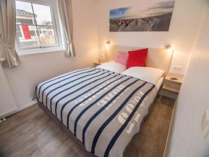 een kleine slaapkamer met een bed en een raam bij Pier98 19 in Scharbeutz +14 foto's