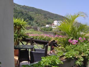 a balcony with a table and chairs and flowers at Rustikale Ferienwohnung mit Balkon und Meerblick in Icod de los Vinos