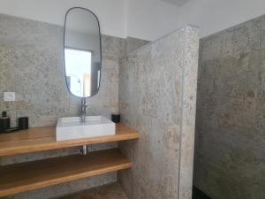łazienka z umywalką i lustrem w obiekcie Maison neuve élégante pour 6 pers. avec climatisation, proche du centre de Saintes-Maries-de-la-Mer - FR-1-475-187 w Saintes-Maries-de-la-Mer