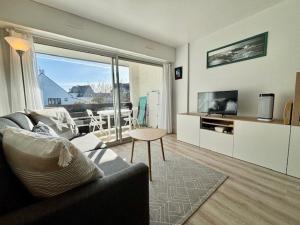 a living room with a couch and a television at Quiberon: Appartement lumineux 2 pièces près de la plage - FR-1-478-309 in Quiberon