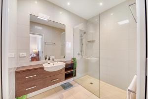 a white bathroom with a sink and a mirror at Jan Juc Beach Home in Torquay +22 photos