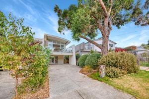 a house with a tree in front of it at Jan Juc Beach Home in Torquay