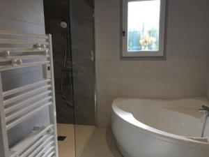 ein Badezimmer mit Badewanne und Waschbecken und einem Fenster in der Unterkunft La grande Seibel in Les Bussolleries