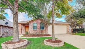 two trees in a yard in front of a house at Charming Frisco Escape Minutes from PGA and The Star in Frisco