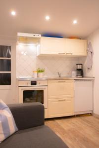 a kitchen with white cabinets and a couch in a room at Twister in Westermarkelsdorf
