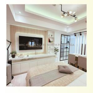 a bedroom with a large bed and a flat screen tv at MRC Homes Azure North Pampanga in San Fernando