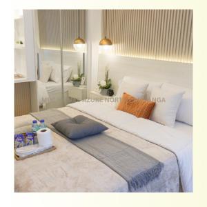 a large white bed in a room with a mirror at MRC Homes Azure North Pampanga in San Fernando