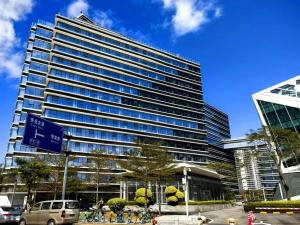 珠海Huafu Seaview Suites的一座高楼，前面停着汽车