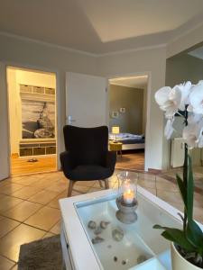 a living room with a chair and a table with a candle at Meerzeit in Zingst
