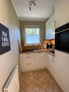 a small kitchen with a sink and a microwave at Meerzeit in Zingst
