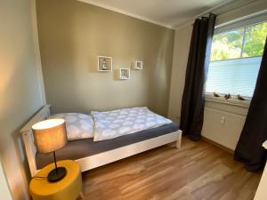 a small bedroom with a bed and a window at Meerzeit in Zingst +11 photos