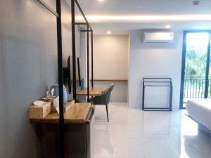 un soggiorno con un letto e una scrivania di Ozone Hotel Khanom a Ban Phang Phrao