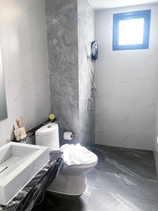 un bagno con un water bianco e un lavandino di Ozone Hotel Khanom a Ban Phang Phrao