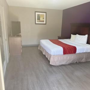 a hotel room with a bed and a flat screen tv at Deluxe inn in Bossier City