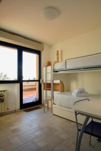 a bedroom with bunk beds and a table and a window at Casa LORY in Varazze