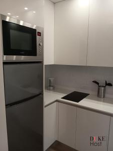 eine Küche mit Kühlschrank und Mikrowelle in der Unterkunft Puerta de Hierro Apartments in Madrid
