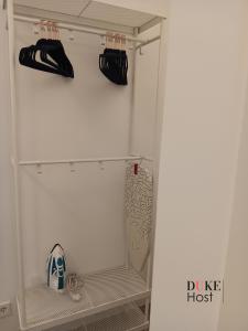 einen Schrank mit einem weißen Kühlschrank mit schwarzer Kleidung in der Unterkunft Puerta de Hierro Apartments in Madrid