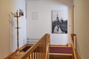 a hallway with a wooden staircase with a cross on the wall at Ferienwohnung im Pfarrhaus Kölzow in Kölzow