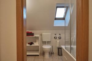 a bathroom with a toilet and a tub and a window at Ferienwohnung im Pfarrhaus Kölzow in Kölzow +6 photos