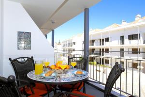 a balcony with a table with oranges and juice at Apartment Karin, Town Centre in Tavira