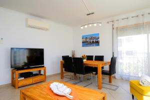 a living room with a dining room table and a tv at Apartment Karin, Town Centre in Tavira
