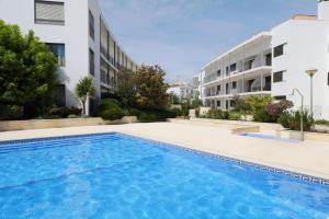 a swimming pool in front of a building at Apartment Karin, Town Centre in Tavira