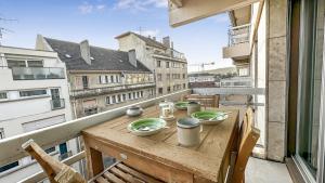 a table on a balcony with a view of a city at Coloc Dormant - Hyper-centre, proche transports pour Genève. in Annemasse