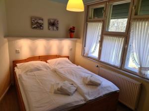 - une chambre avec un lit doté de draps blancs et 2 fenêtres dans l'établissement Haus Otto - Whg 1, à Wyk auf Föhr