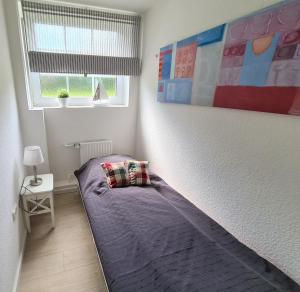 a small bedroom with a bed with a purple blanket at Bootshaus Nr 6 in Grömitz