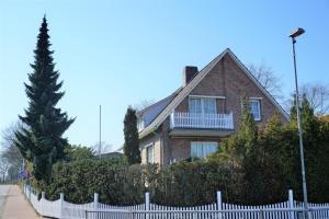 a house with a white fence in front of it at Bootshaus Nr 6 in Grömitz