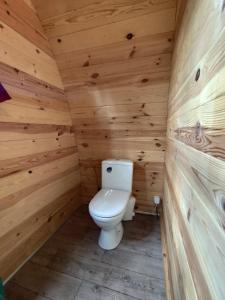a bathroom with a toilet in a wooden cabin at Glamping POD am See in Wittenborn +3 photos