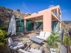 dom z patio z krzesłami i stołem w obiekcie Salobre Villas w mieście Salobre