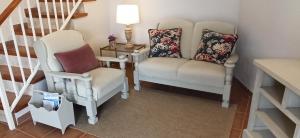 ein Wohnzimmer mit zwei Stühlen und einer Lampe in der Unterkunft Ca La Silvia Masboquera in Mas Boquera + 17 Fotos