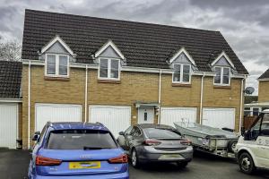 una casa con dos coches aparcados en un estacionamiento en K Suites - Shetland Court, en Bridgwater